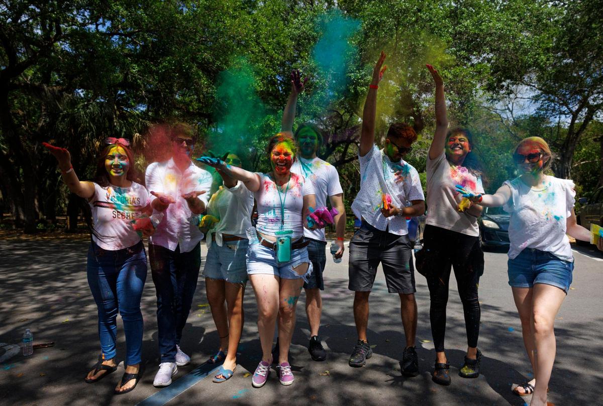 Nancy Orduno, center, and Himani Bhatt, left, and their friends throw colored powder in the air during the celebration of Holi, the Hindu festival of colors at Kendall Indian Hammocks Park. The colors are a way of showing affection towards each other. “It celebrates the goodness over evil and friendship,” said one of their friends.