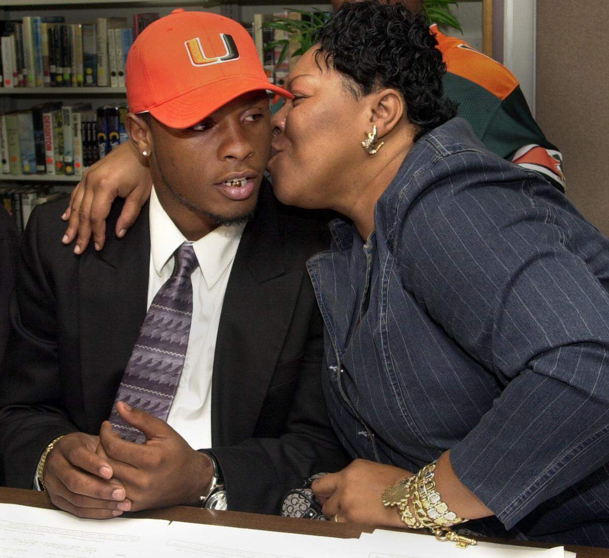 to Sports2/4/04---Donna E. Natale Planas/Herald Staff---Miami---Today is National Signing Day.....Pictured here is Killian High School football player, Bobby Washington getting a big kiss from his mother, Leslie Washington Mortimer after sighing with the University of Miami. To go with story by Andre Fernandez, (2 of 4 Photos)