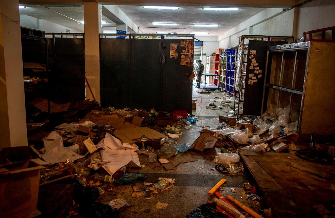 Soldiers stand guard at the entrance of a store looted by demonstrators the night before, in Ciudad Bolivar, Venezuela, Monday, Dec. 19, 2016.