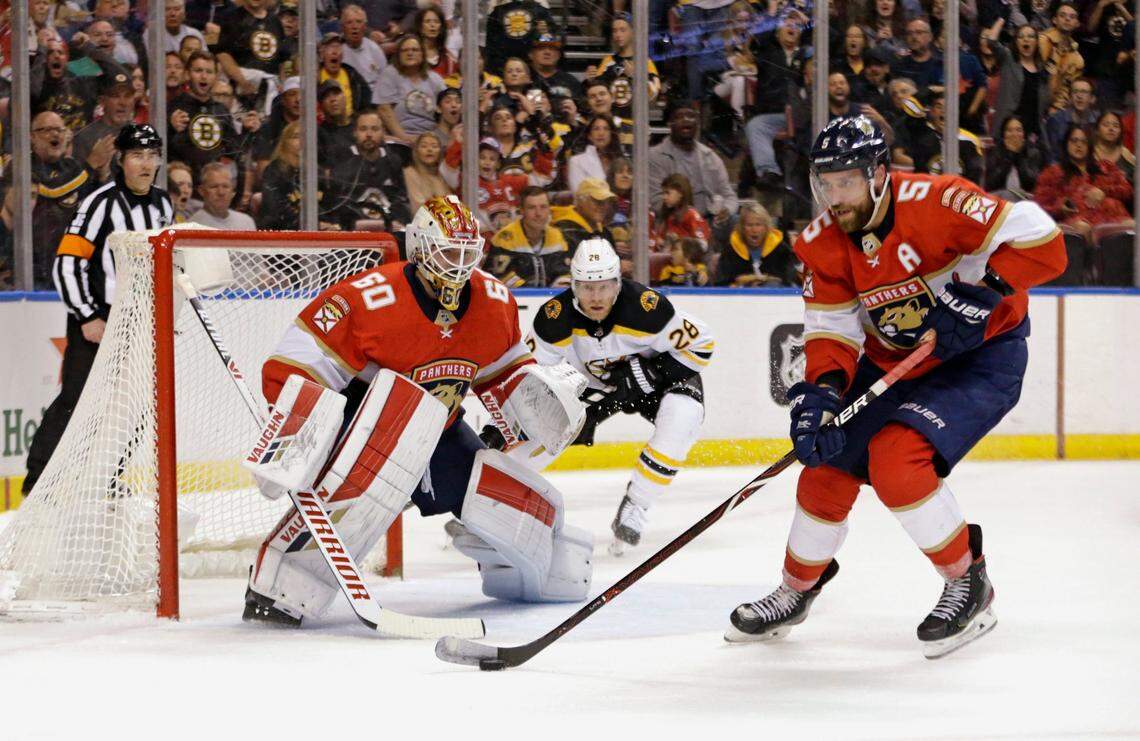 Florida Panthers goalie Chris Driedger (60) defends the goal from Boston Bruins right wing Ondrej Kase (28) as teammate defenseman Aaron Ekblad (5) skate for the puck during the first period&nbsp;of an NHL regular season hockey game at the BB&T Center on Thursday, March 5, 2020 in Sunrise.
