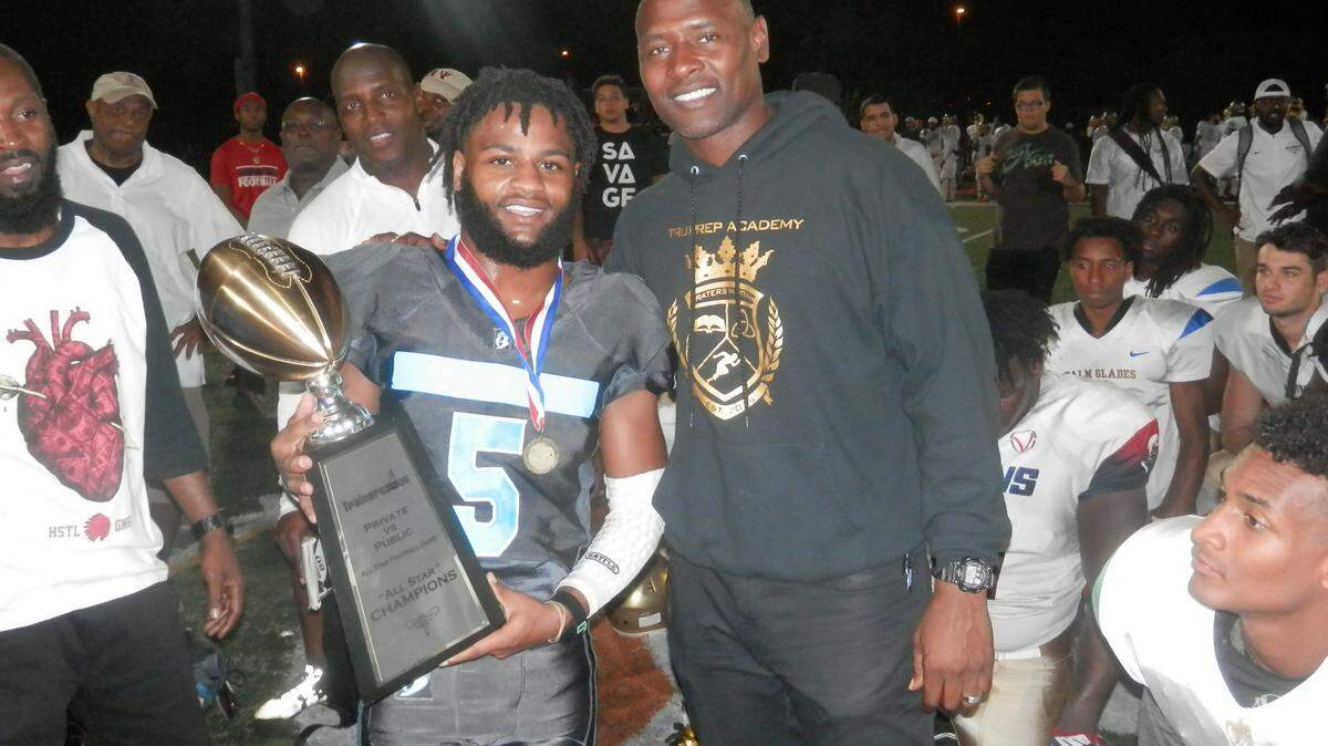 Standing with Tru Sports Foundation President and game organizer Mario Smith, Jackson running back Trenod Desrosier was presented the MVP trophy after leading his Public All Stars to a 27-20 victory over the Private team at Ives Estates Park.