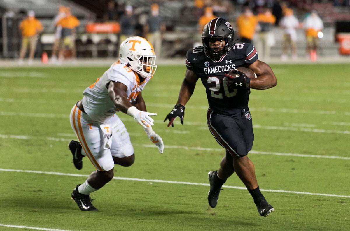 South Carolina running back Kevin Harris (20) carries for a touchdown, next to Tennessee linebacker Deandre Johnson (13) during the first half of an NCAA college football game Saturday, Sept. 26, 2020, in Columbia, S.C. (AP Photo/Sean Rayford)