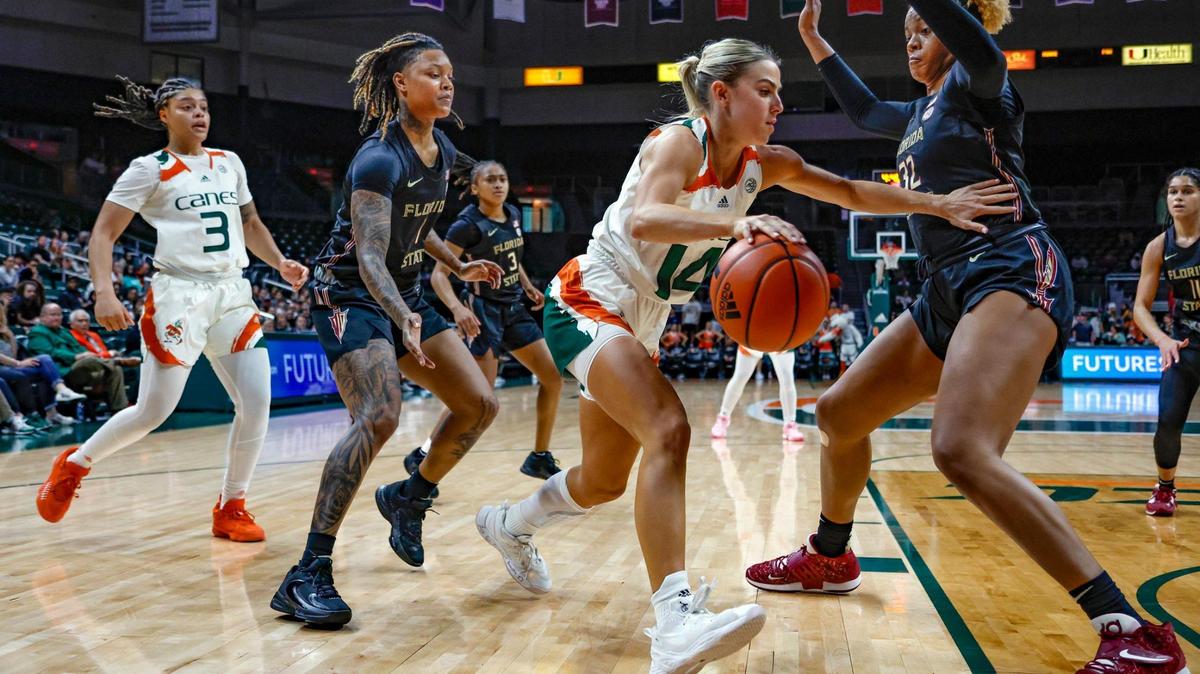 Miami Hurricanes guard Haley Cavinder (14) drives the ball to the basket as Florida State Seminoles forward Valencia Myers (32) defends in the first half at the Watsco Center in Coral Gables, Fl. on Thursday, February 9, 2023.