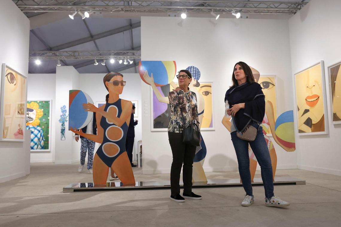 Sara Adler, left, and Vicki Miller admire artwork outside of the David Benrimon gallery booth filled with Alex Katz’s work during the opening night of VIP for Art Miami on Tuesday, Nov. 29, 2022, at CONTEXT Art Miami.