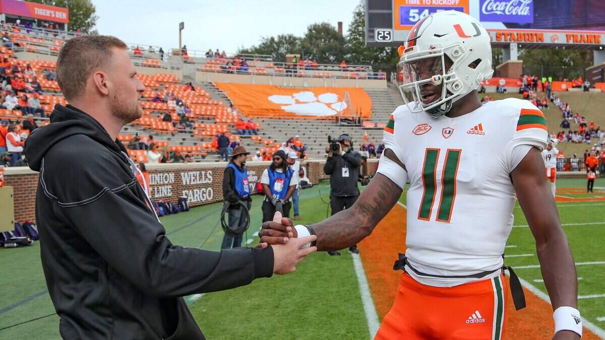 At right, Miami Hurricanes quarterback Tyler Van Dyke (9) greets quarterback Jacurri Brown (11) during warmups before the game against the Clemson Tigers at Frank Howard Field at Clemson Memorial Stadium in Clemson, South Carolina on Saturday, November 19, 2022.