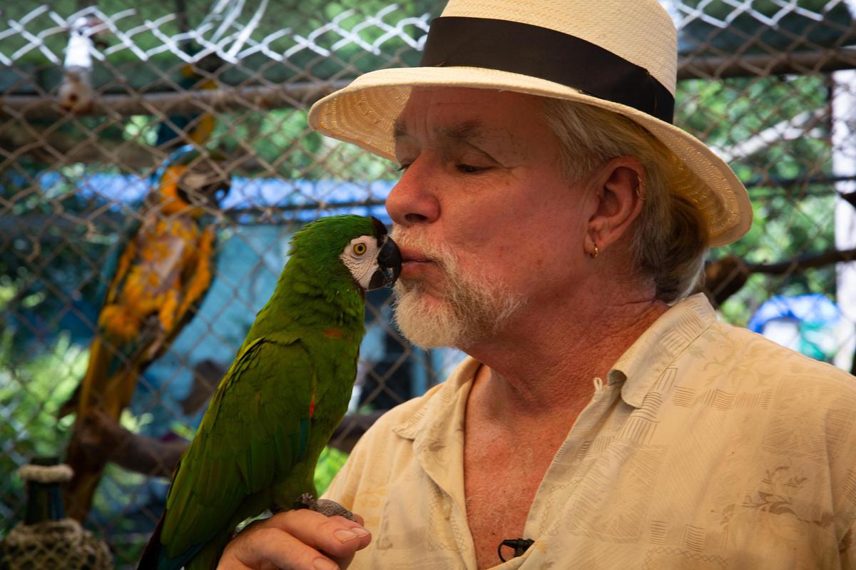 Daniel Wukits of Micco comforts one of his many parrots at the Galleon Treasures Parrot Sanctuary & Botanical Gardens on Saturday. He spent days searching for a safe location to evacuate the 180 exotic birds in advance of Hurricane Dorian.