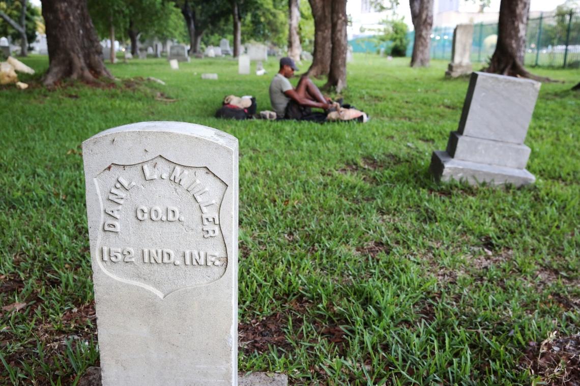 A homeless man packs up his belonging as the gates to the Miami City Cemetery were being closed for the evening, June 4, 2018. Damage to graves and trespassing by drug addicts and Santeria worshippers who deposit offerings are ongoing problems at Miami's oldest graveyards.