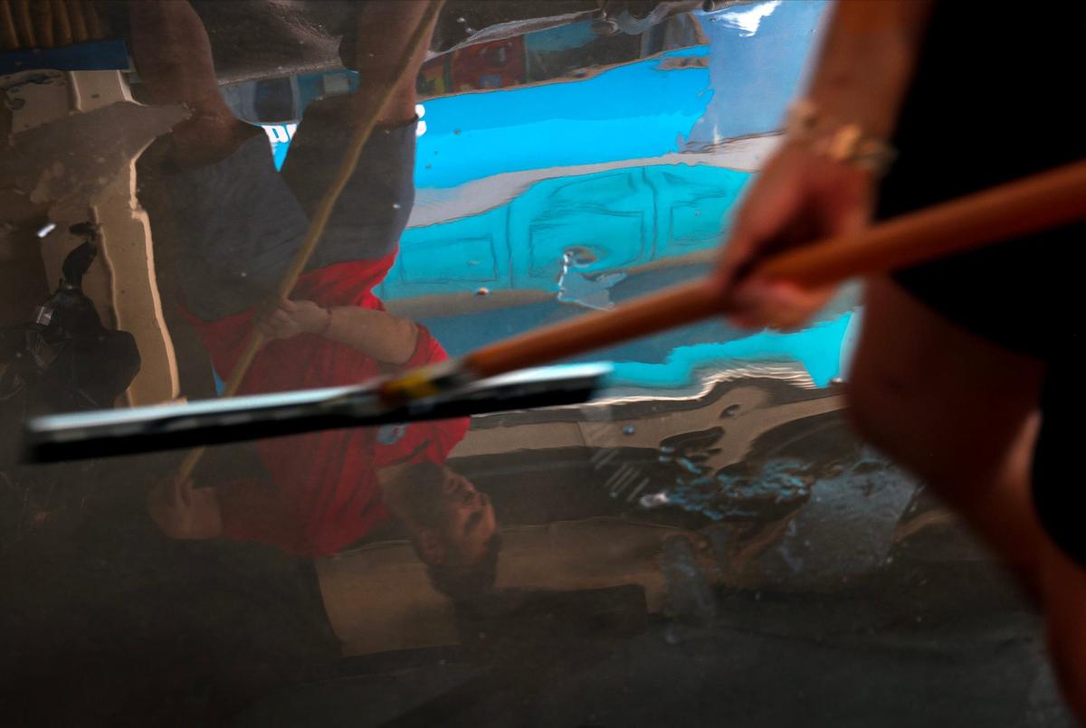 Daniel Clarkston, 36, owner of Mr. Wave Island, pushes mud water out of the bar and grill in Ft. Myers Beach.