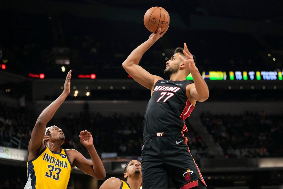 Miami Heat center Omer Yurtseven (77) shoots over Indiana Pacers center Myles Turner during the first half of an NBA basketball game in Indianapolis, Friday, Dec. 3, 2021. (AP Photo/AJ Mast)