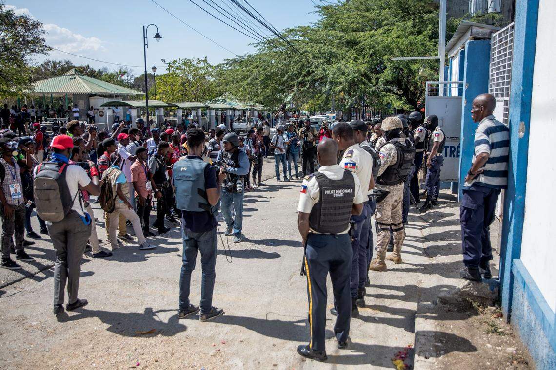 Journalists face armed police as they gather outside the Departmental Directorate of Haiti National Police to file a complaint after they were targeted with tear gas while covering a protest against the Haitian president in Port-au-Prince, February 10, 2021. Haitian police fired tear gas on hundreds of protesters who were marching against President Jovenel Moise in Port-au-Prince on February 10, and attacked journalists covering the demonstration, in the latest clashes to mark the country’s political crisis.