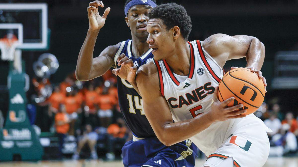 Miami Hurricanes forward Malik Reneau (5) drives the ball as Georgia Tech Yellow Jackets forward Kowacie Reeves Jr. (14) defends during the second half of an NCAA basketball game at the Watsco Center on the University of Miami Campus on Saturday, January 10, 2026 in Coral Gables, Florida.