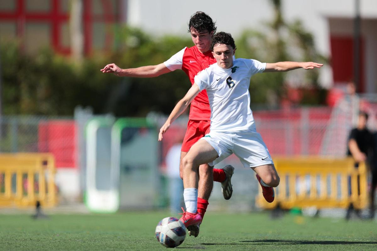 Downtown Doral defender Gianluca Tortolani (6) protects the ball from MAST Academy midfielder Santiago Casserly (10) during the first half of a boys soccer Region 4-3A quarterfinal playoff game at MAST Academy in Miami, Florida, Tuesday, February 11, 2025.