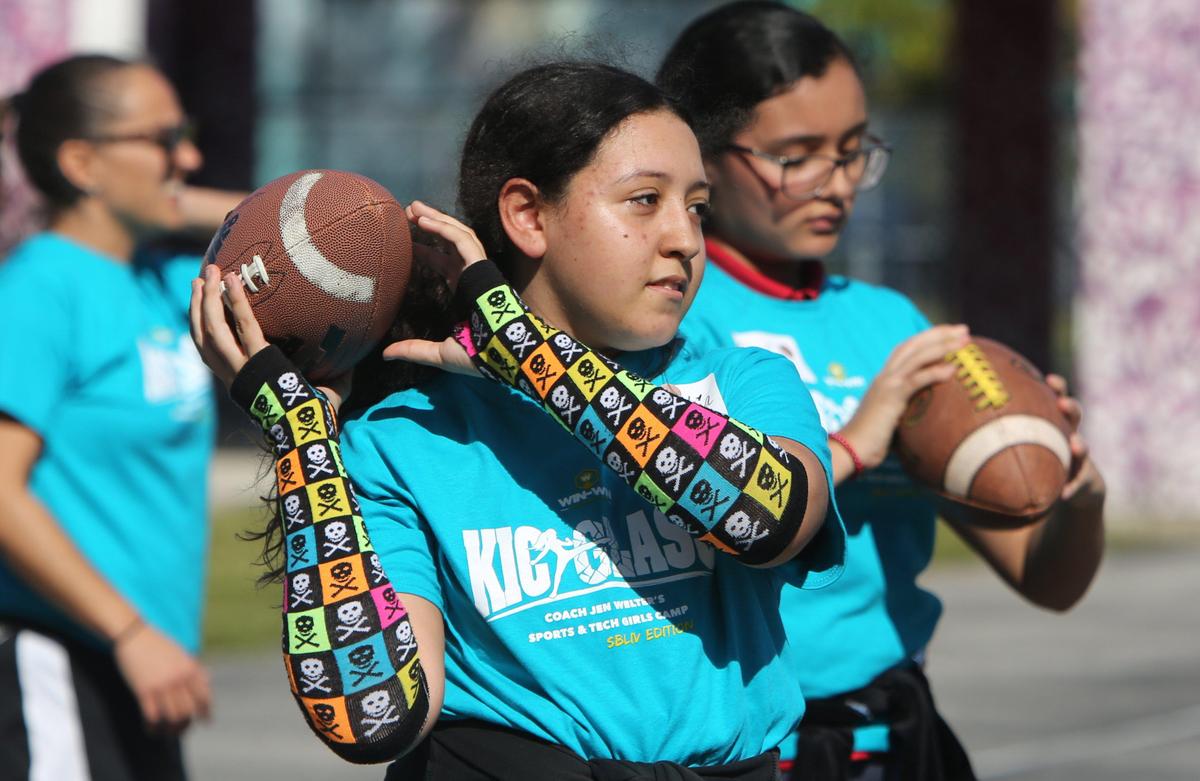 Natalia Burgos,13, learns how to throw a football during the KickGlass Sports Meets Tech Camp, at her school, Jose De Diego Middle School, Thursday, January 30, 2020.