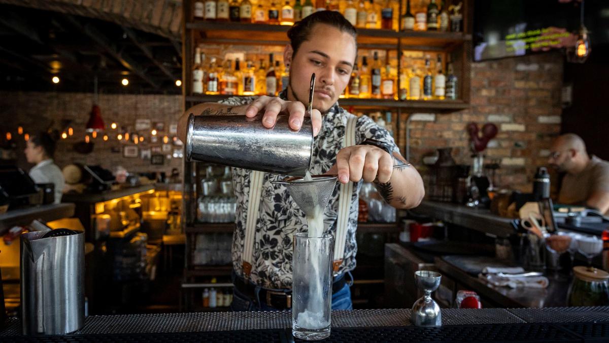 Bartender Carlos Irias mixes up a mojito at the bar in Finka Table & Tap in Miami.