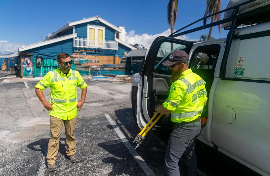 James Fountain, 40, right, and David Hough, 30, both with the U.S. Geological Survey, arrive at the Nauti Parrot Dock Bar on Tuesday, Oct. 18, 2022, in Fort Myers Beach, Florida.