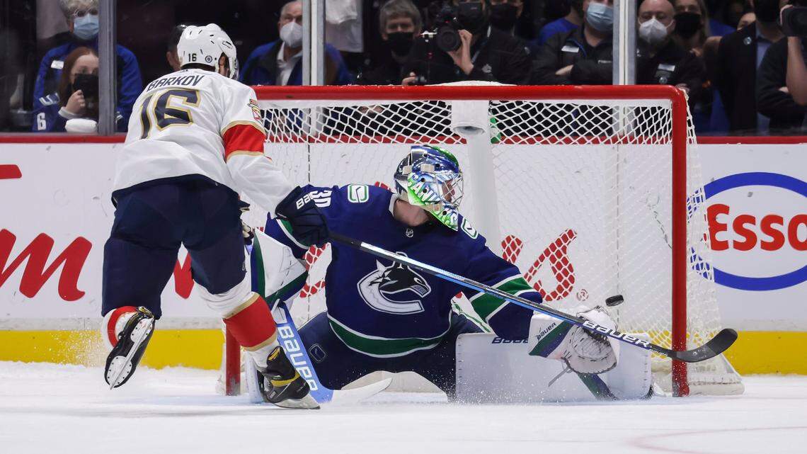 Florida Panthers’ Aleksander Barkov, left, scores against Vancouver Canucks goalie Spencer Martin during the shootout in an NHL hockey game Friday, Jan. 21, 2022, in Vancouver, British Columbia.