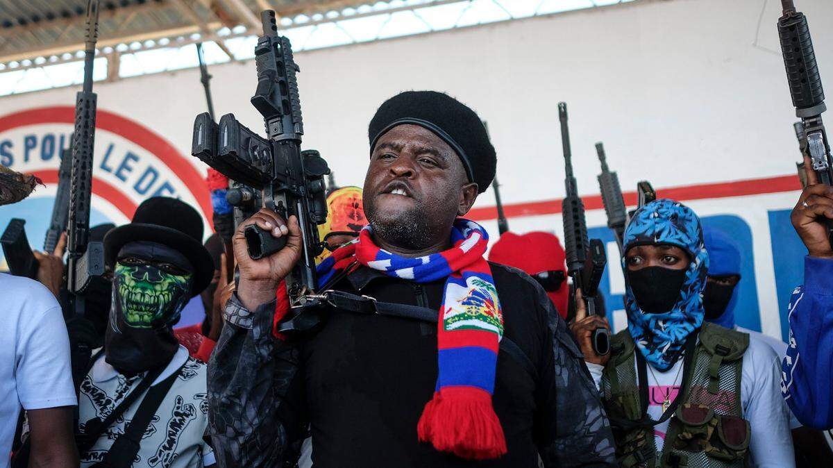 Gang leader Jimmy Cherizier, better known as Barbecue, shouts slogans with his gang members after giving a speech, as he leads a march through the La Saline neighborhood in Port-au-Prince, Haiti, on Oct. 22, 2021.