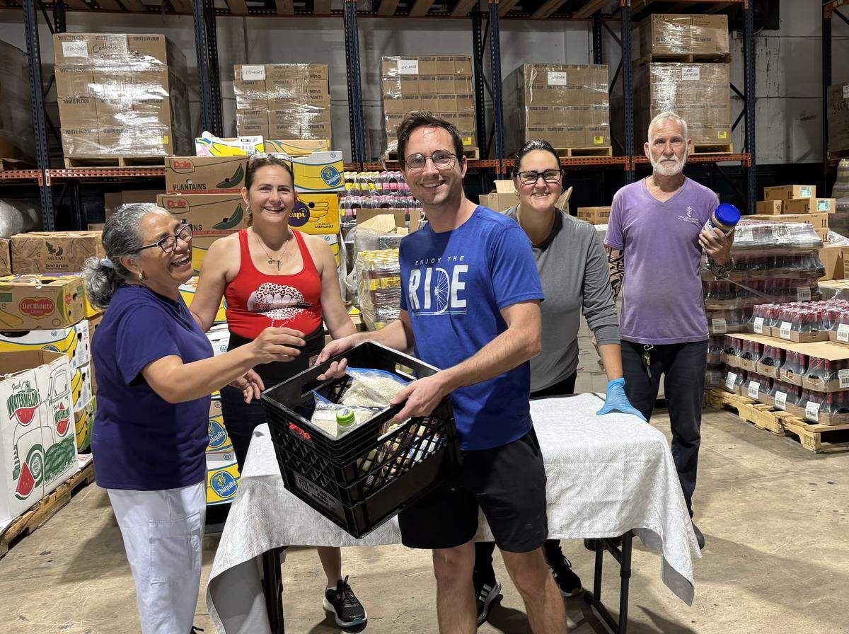Volunteers pack crates with food items at Matthew 25, a food pantry owned and operated by Catholic Charities. The food pantry serves 1,300 families per month, but is currently experiencing a shortage in protein items.