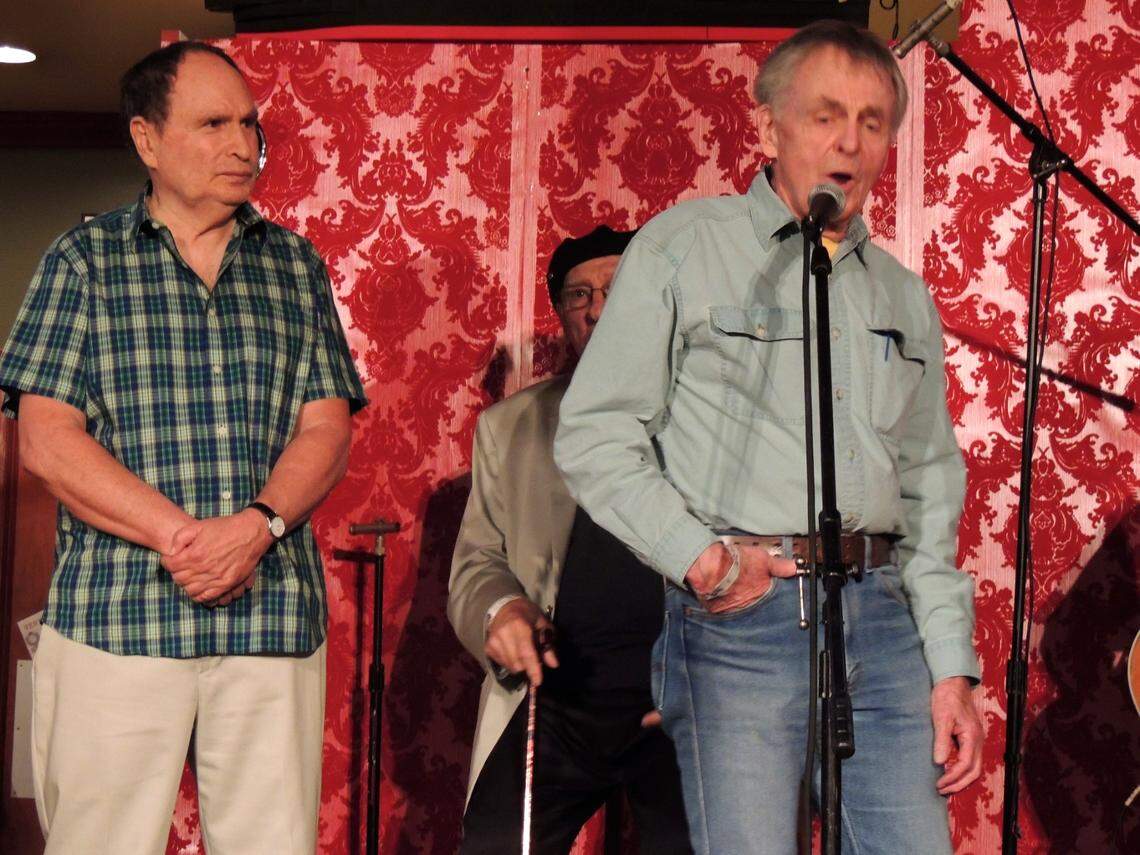 Gabe Kaplan, left, takes a break from hosting duties to listen to Chuck Mitchell, Joni Mitchell’s first husband, as the singer-songwriter pays tribute to the late Steve Goodman by singing Goodman’s classic, “City of New Orleans,” at a 50th anniversary tribute to The Flick Coffeehouse on March 28, 2014. The three-day festival was held in The Flick’s original spot in Coral Gables in what is now Titanic Restaurant & Brewery.
