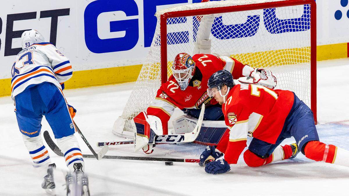 Florida Panthers defenseman Niko Mikkola (77) helps Panthers goaltender Sergei Bobrovsky (72) defend the net against pressure from the Edmonton Oilers center Ryan Nugent-Hopkins (93) during the second eriod of Game 2 of the NHL Stanley Cup Final at the Amerant Bank Arena on Monday, June 10, 2024, in Sunrise, Fla.