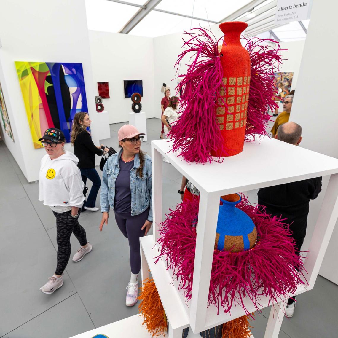 Guests walk past Alfred Lowe’s ceramic pieces at Untitled Art Fair on Tuesday, Dec. 3, 2024, in Miami Beach, Fla.