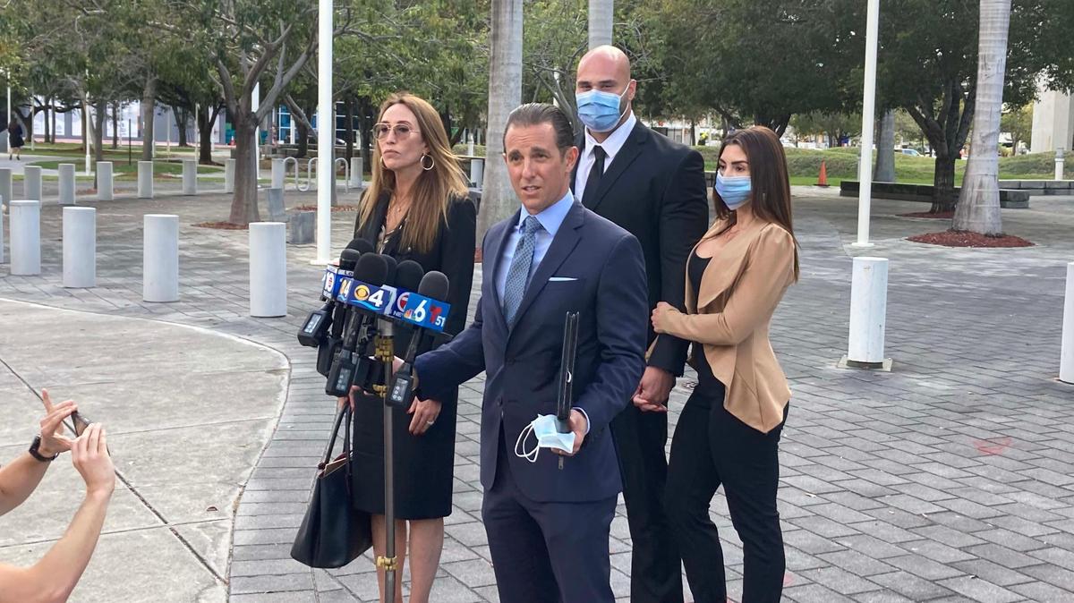 El ex oficial de policía de Hialeah, Jesús Menocal Jr., en la parte trasera central, se encuentra con su esposa y sus abogados frente a la corte federal de Miami el viernes después de aceptar un acuerdo de culpabilidad que lo enviará a prisión por hasta tres años por cargos menores por presionar a tres víctimas a tener relaciones sexuales mientras estaba de servicio. Sus abogados son Mycki Ratzan, a la izquierda, y Jude Faccidomo.