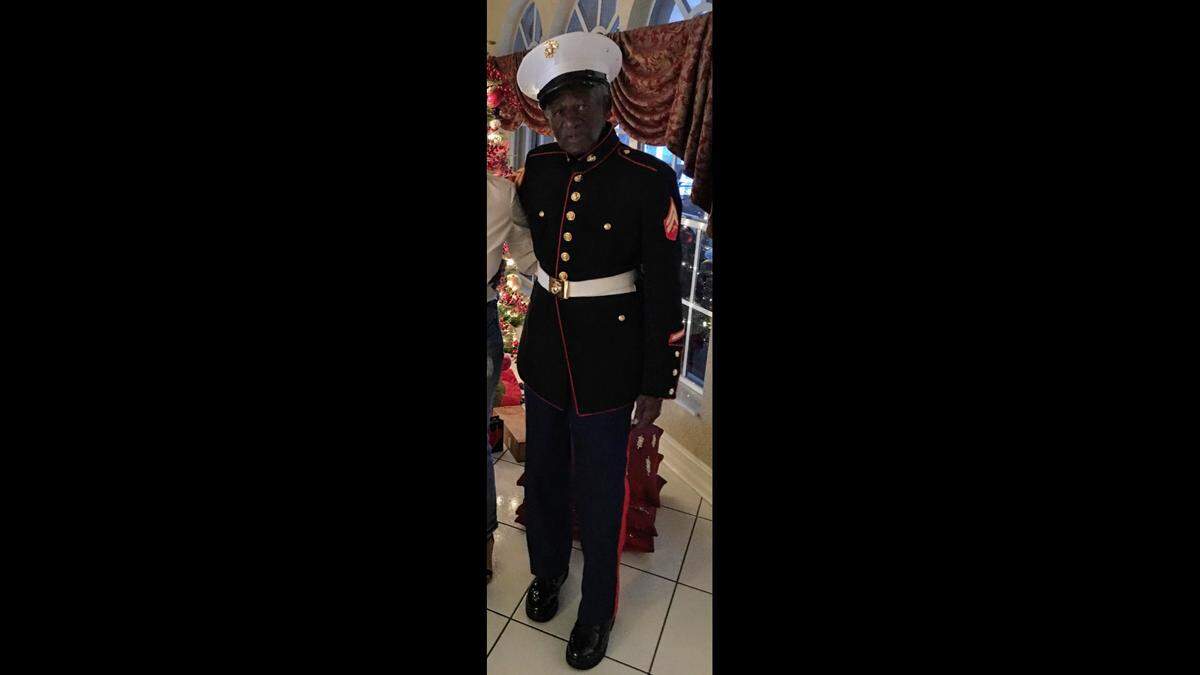 George J. Johnson stands in his dress blue uniform from his days as a United States Marine.