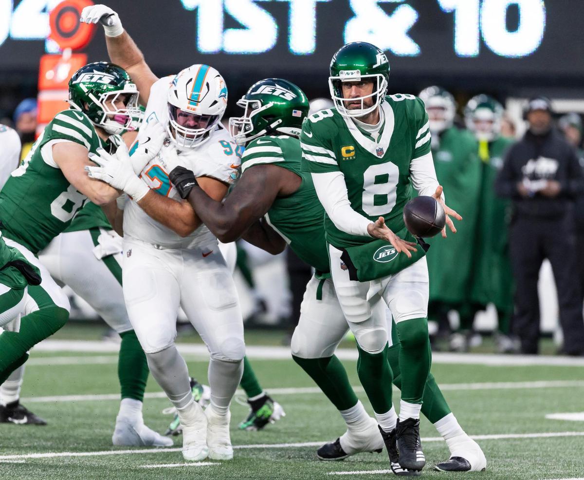 New York Jets quarterback Aaron Rodgers (8) passes the ball as Miami Dolphins defensive tackle Zach Sieler (92) tries to sack him in the first half of their NFL game at MetLife Stadium on Sunday, Jan. 5, 2025, in East Rutherford, N.J.