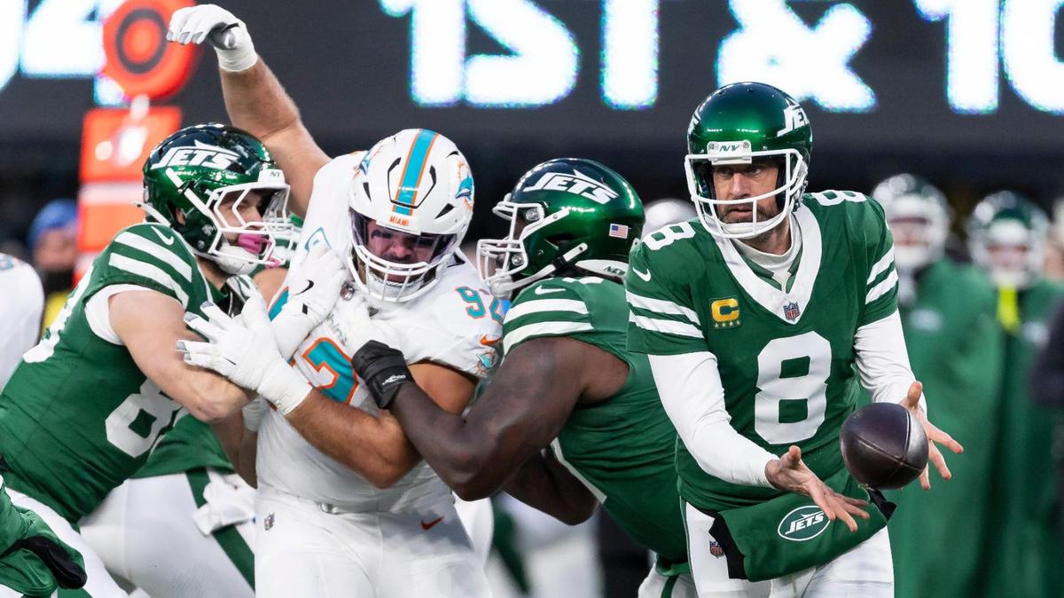 New York Jets quarterback Aaron Rodgers (8) passes the ball as Miami Dolphins defensive tackle Zach Sieler (92) tries to sack him in the first half of their NFL game at MetLife Stadium on Sunday, Jan. 5, 2025, in East Rutherford, N.J.