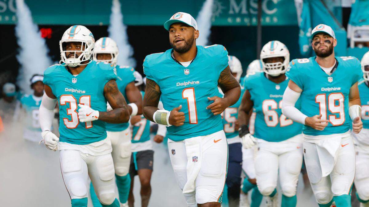 Miami Dolphins quarterback Tua Tagovailoa (1) runs onto the field with teammates for the start of the game against the Washington Commanders at Hard Rock Stadium in Miami Gardens, Florida on Saturday, August 17, 2024.