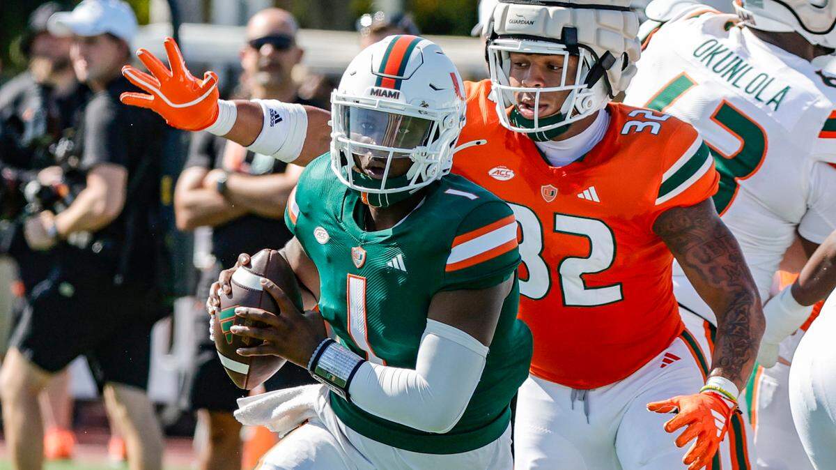 Miami Hurricanes quarterback Cam Ward (1) scrambles out of the pocket as Miami Hurricanes linebacker Raul Aguirre Jr. (32) gives chase during the Canes spring football game at the University of Miami’s Cobb Stadium in Coral Gables, Florida on Saturday, April 13, 2024.