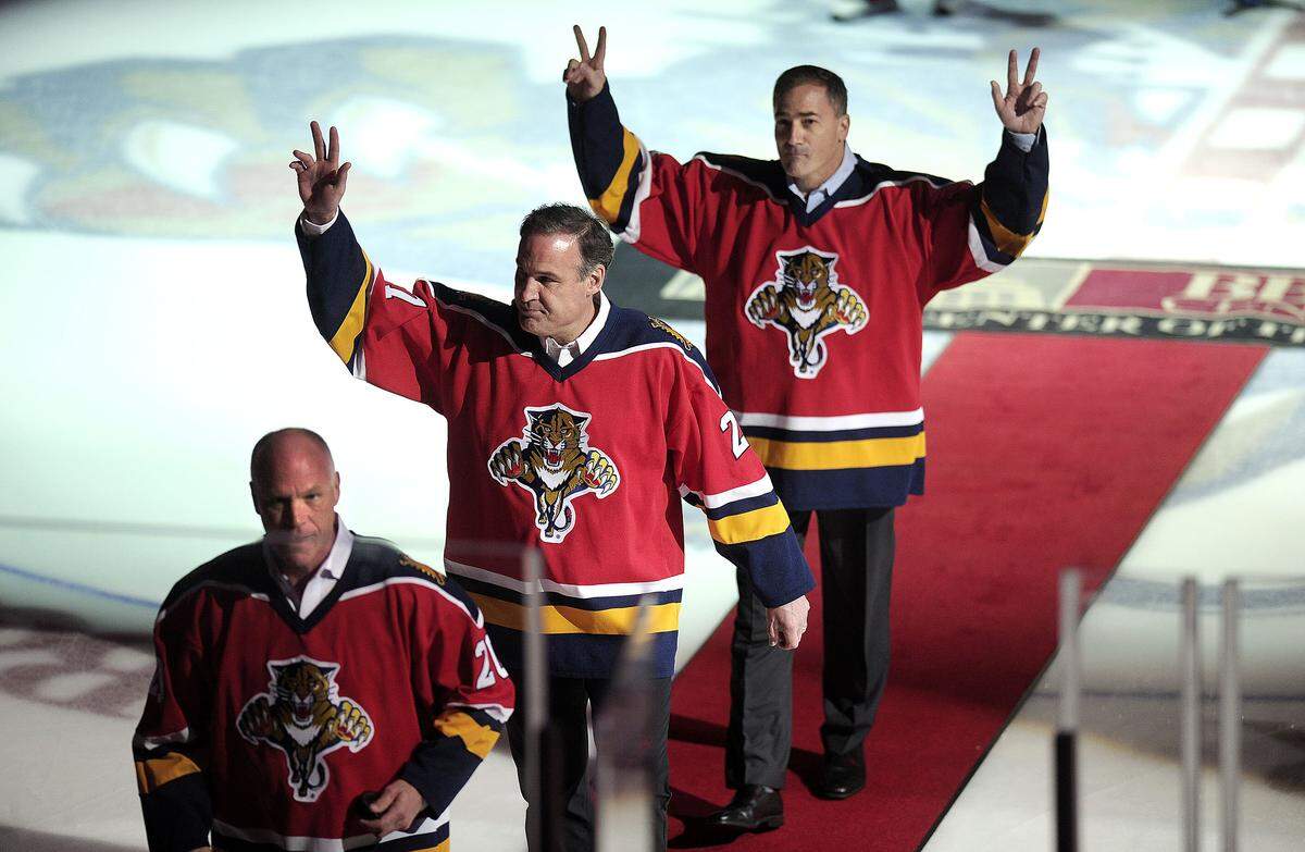 Members of the 1996 Florida Panthers hockey team, from left, Brian Skrudland, Scott Mellanby and John Vanbiesbrouck walk off the ice after participating in a ceremonial puck drop before the Panthers game against the Philadelphia Flyers, Saturday, March 12, 2016.