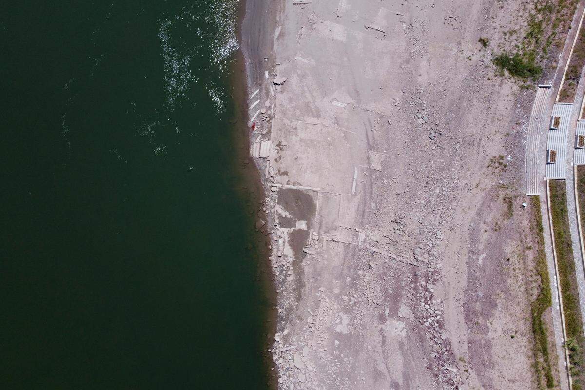 In this aerial photo, the lower than normal bank of the Jialing River is seen in southwestern China’s Chongqing Municipality, Friday, Aug. 19, 2022. Ships crept down the middle of the Yangtze on Friday after the driest summer in six decades left one of the mightiest rivers shrunk to barely half its normal width and set off a scramble to contain damage to a weak economy in a politically sensitive year. (AP Photo/Olivia Zhang)