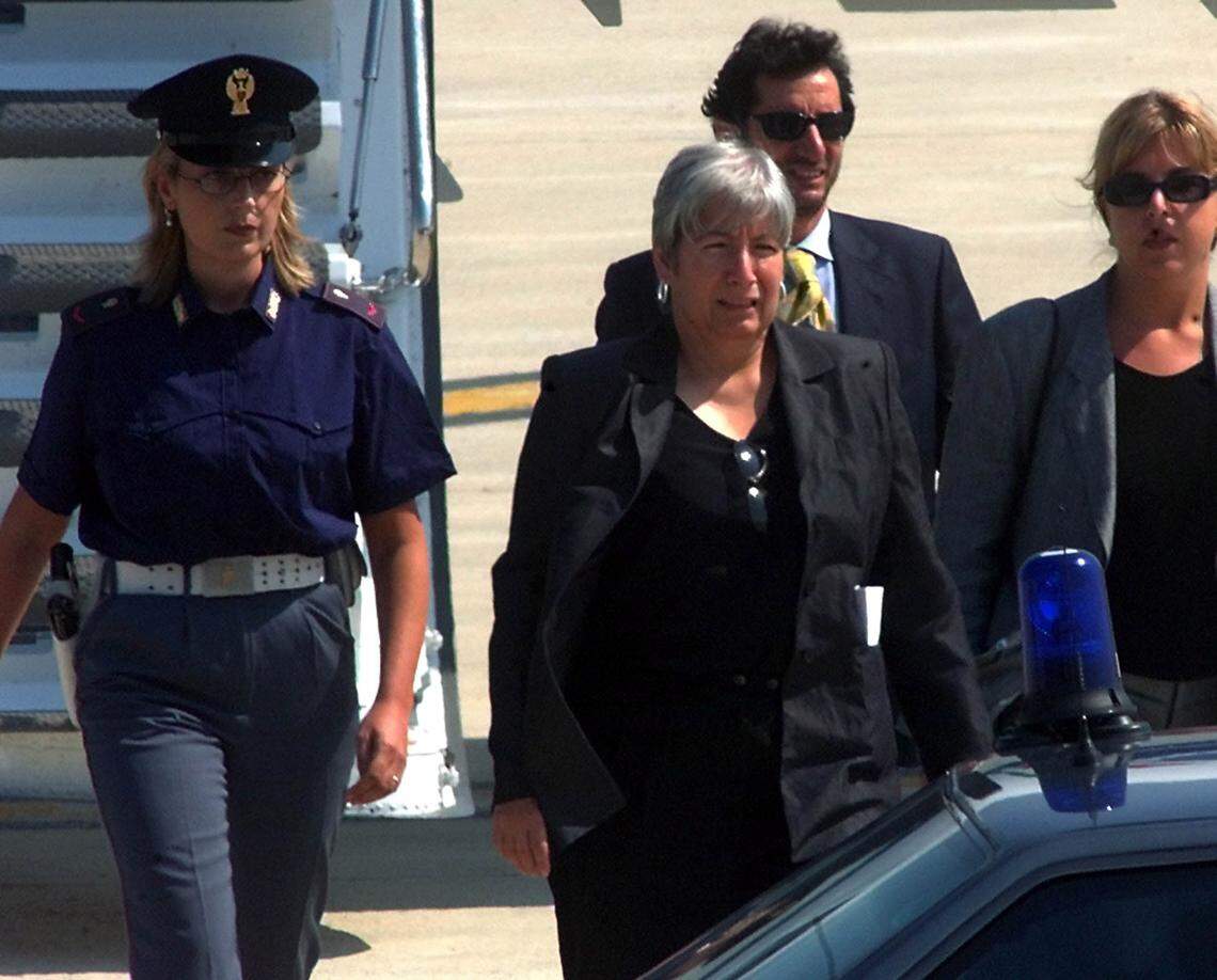 An August 25, 1999, file photo shows police escorting Italian convict Silvia Baraldini, center. She was assigned to house arrest due to health reasons in Rome on April 21, 2001. Baraldini was convicted in the United States for armed robberies that financed a leftist terrorist organization and has been in Italy since 1999 to cure breast cancer.
