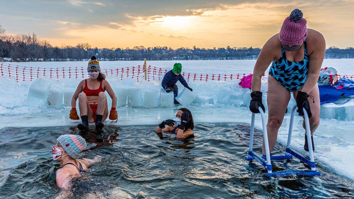 Members of the “Submergents” group take the plunge into 37.4° F (3° C) water in a “pool” carved from the ice at Lake Harriet in Minneapolis, Minnesota, on January 30, 2021.