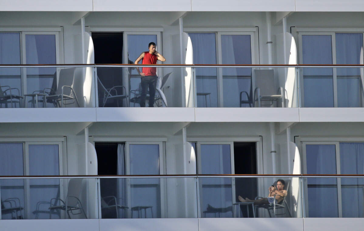Miembros de la tripulación en sus balcones a bordo del Norwegian Encore en PortMiami el jueves 26 de marzo de 2020.