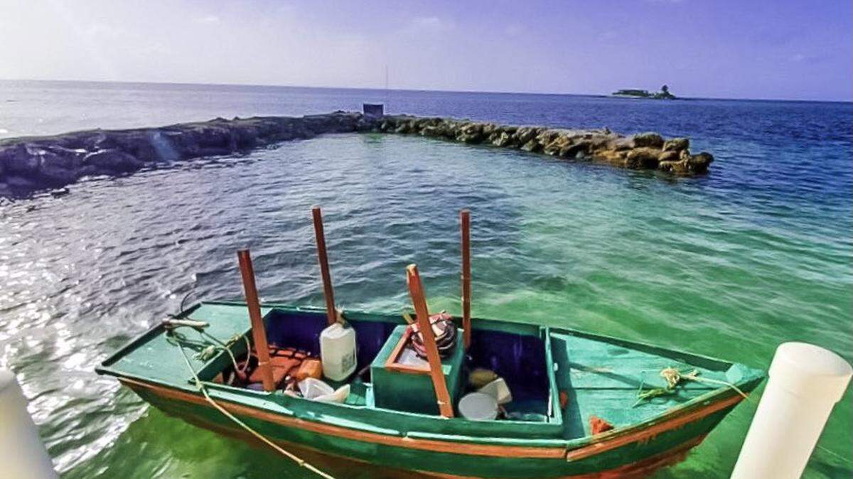 A small, green wooden fishing vessel is tied up on a dock in the Middle Florida Keys city of Marathon Thursday, Sept. 2, 2021. The U.S. Border Patrol said six people from Cuba arrived on the boat that morning.