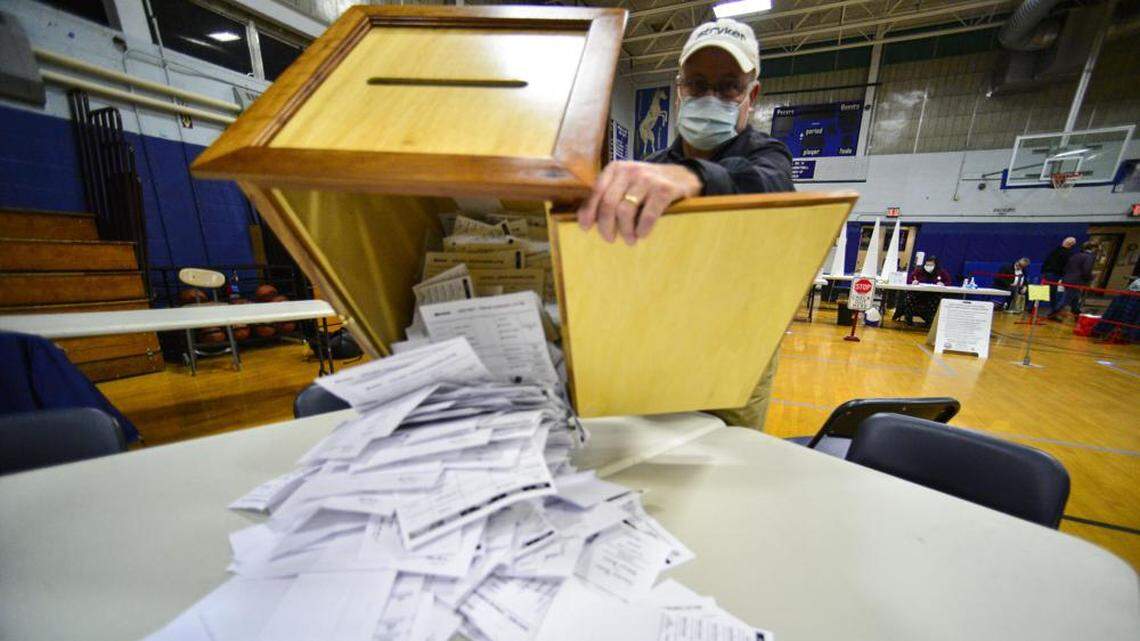 Steve Diorio dumps out nearly 1,900 ballots onto a table to be hand-counted at a New Hampshire high school.