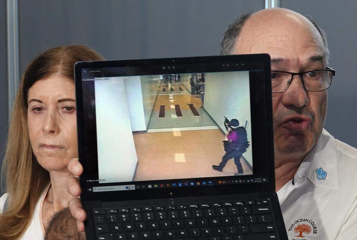 "Esto fue lo último que vio mi hijo", dice Michael Schulman, sosteniendo una captura de pantalla del tiroteo de Parkland mientras su esposa Linda Beigel Schulman mira, después de que el jurado recomendara cadena perpetua para el tirador de la Secundaria Marjory Stoneman Douglas Nikolas Cruz en el Tribunal del Condado Broward, en Fort Lauderdale, el jueves 13 de octubre de 2022. El hijo de la pareja, el entrenador de campo traviesa Scott Beigel, murió en el tiroteo de 2018. (Joe Cavaretta/South Florida Sun Sentinel vía AP, Pool)