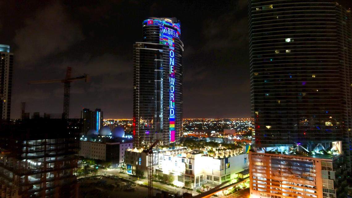 The 60-story Paramount Miami Worldcenter at 851 NE First Ave in Downtown Miami, will light up every night with hundreds of fluttering flags and the words “One World, One Prayer,” until all of the missing people in Surfside’s building collapse are found. Pictured above is a May 19, 2020 photo when the skyscraper was lit up during the week of the 39th annual funeral observance of music legend Bob Marley. (Bryan Glazer/World Satellite Television News via AP Images)