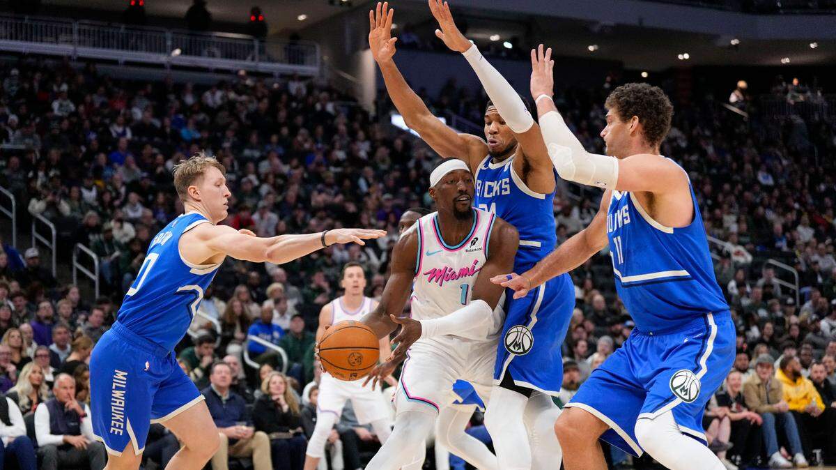 Miami Heat center Bam Adebayo (13) looks tp pass the ball under pressure from Milwaukee Bucks guard AJ Green (20), forward Giannis Antetokounmpo (34) and center Brook Lopez (11) during the third quarter at Fiserv Forum.