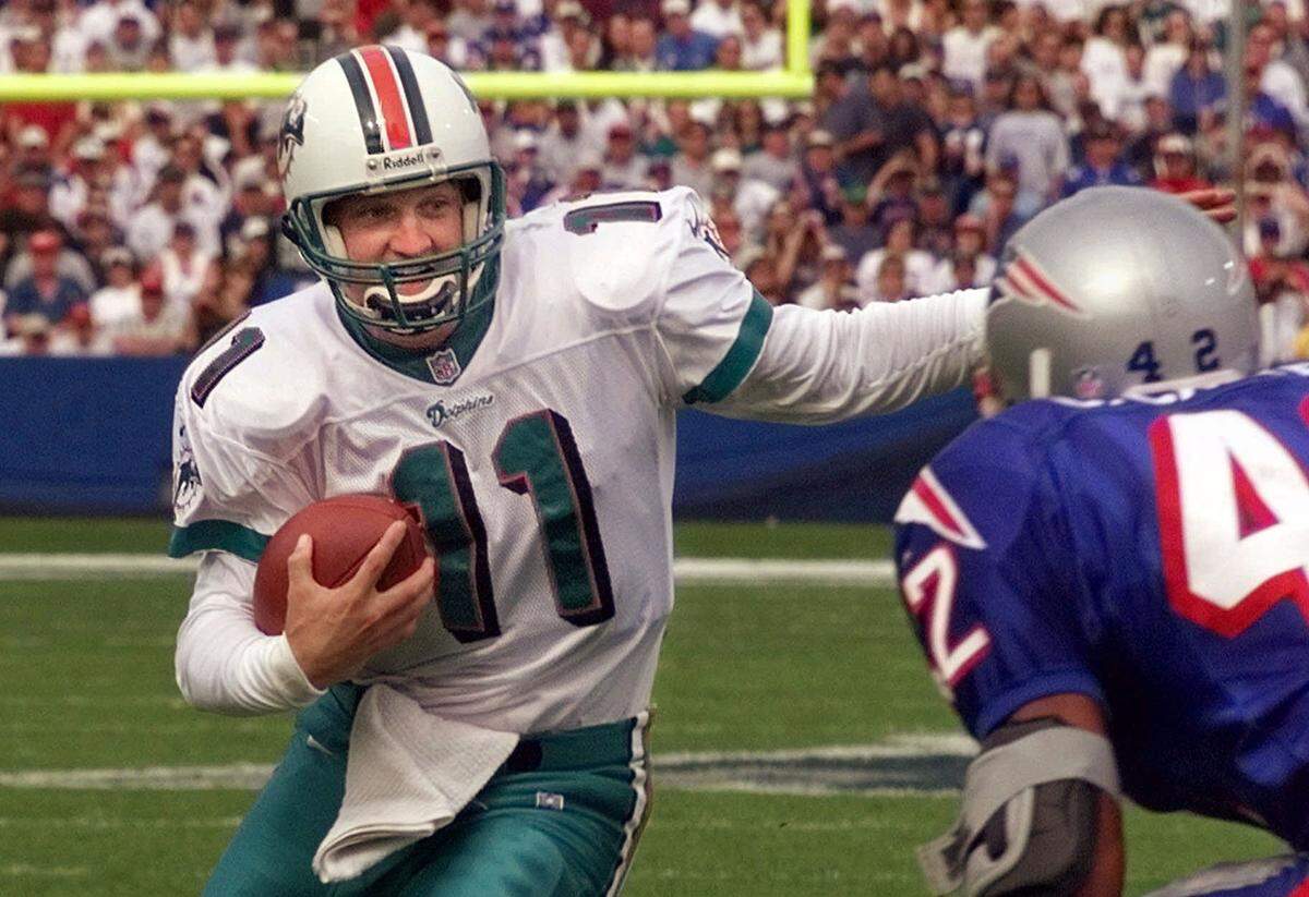 Miami Dolphins backup quarterback Damon Huard (11) looks for a way around New England Patriots saftey Chris Carter (42) on a quarterback keeper during first quarter action of their AFC Eastgame at Foxboro Stadium in Foxboro, Mass., Sunday afternoon Oct. 17, 1999. Huard replaced Dan Marino after Marino threw two first quarter interceptions for touchdowns.