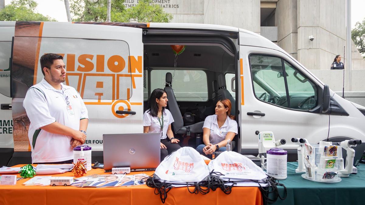 Kevin Zagoya, left, Nada Fareed, center, and Emilie Mikhail work at the UM Vision Van table during the naming ceremony of the UHealth Jackson Metro Station, formerly known as the Civic Center Station, on Friday, July 12, 2024 in Miami, Fla.