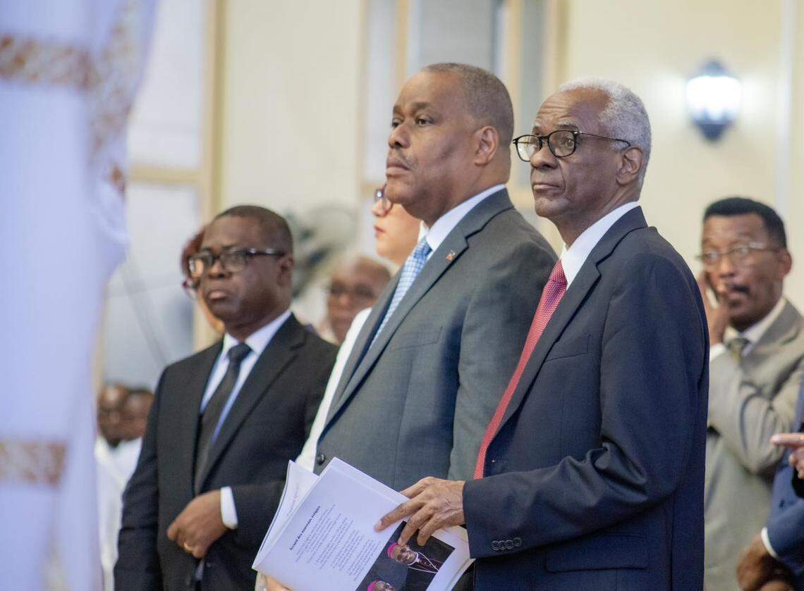 Former Sen. Edgard Leblanc Fils (left) stands next to Interim Prime Minister Garry Conille (right) during a Catholic Mass. Leblanc heads Haiti’s nine-member presidential council, which is being accused, along with Conille, of standing silent amid accusations that three council members asked the head of a state-owned commercial bank for a bribe to keep his job.