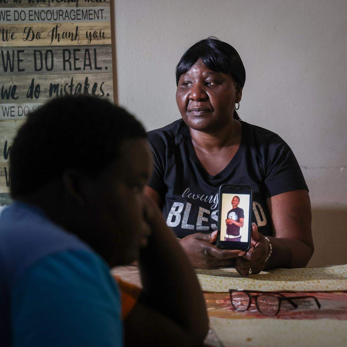 Lasonja Mills Vandyke, 57, holds a photo of her son Brandon Mills on July 25 in Miami. She is demanding answers after the State Attorney’s Office gave immunity to Brandon’s killer in a plea deal. On the left is her grandson Timothy Griffin, 13.