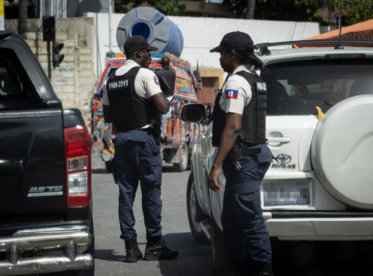 Haiti National Police officers check identifications at a checkpoint in Port-au-Prince on Sunday, June 19, 2022.