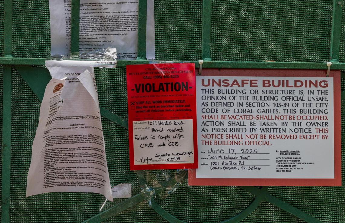 Violation notices from the city of Coral Gables are posted on a fence at the entrance to a vacant landmark 1925 house that is in danger of collapse after years of neglect by its owners. The city is stepping in to shore up the shell of the house.