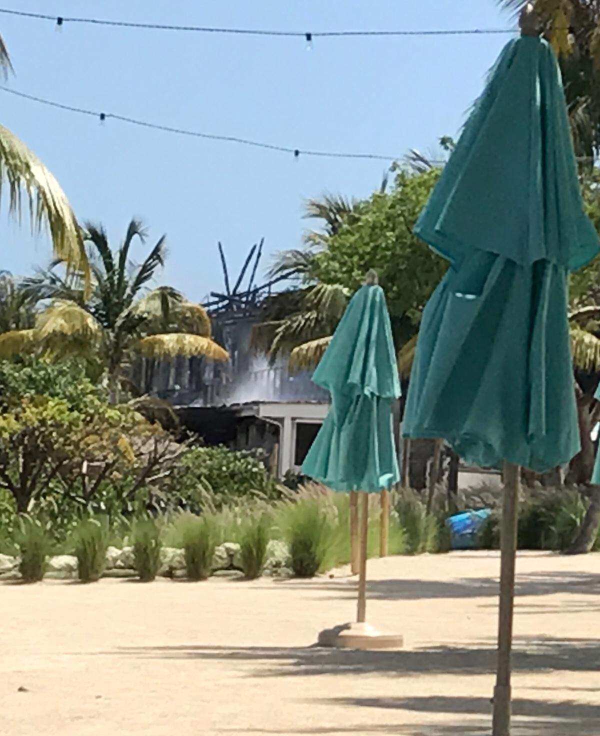 Smoke continues to pour out from the main building at Bungalows Key Largo on May 6, 2019, more than 24 hours after the fire started. A new report says the cause of the fire was accidental.