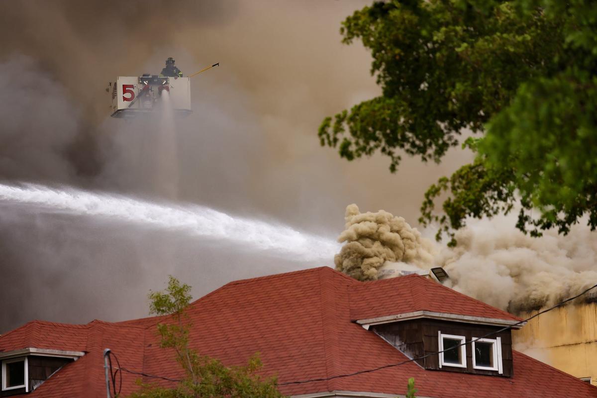 Firefighters aim their hoses at the burjing apartment building..