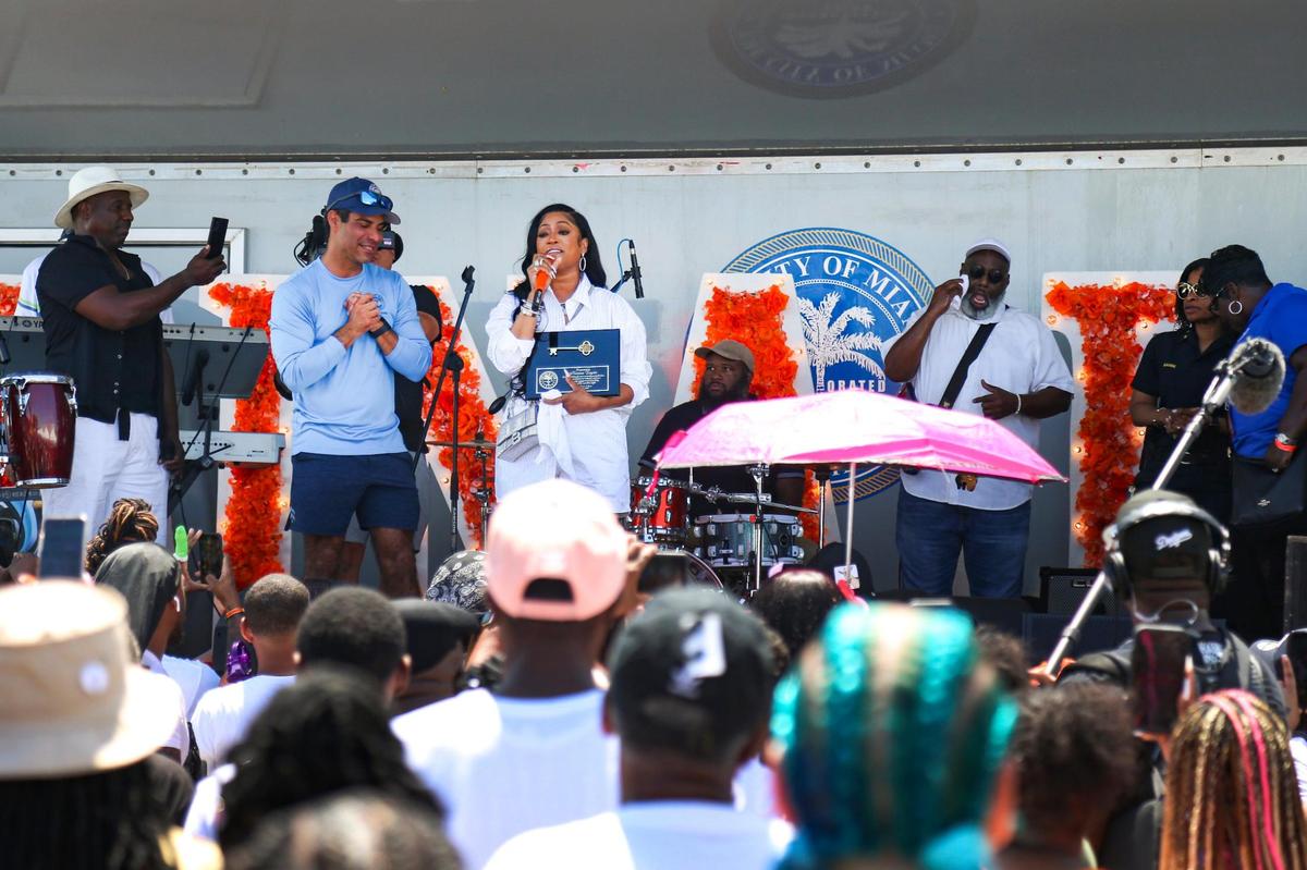 Katrina Taylor, the rapper known professionally as Trina, talks to a crowd of people after receiving the key to the city from Miami Mayor Francis X. Suarez, left, during a block party on NW 15th Avenue between NW 63rd and 65th Street, celebrating Trina Day in Liberty City, Florida, on Saturday, May 14, 2022.